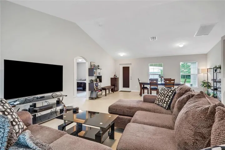 Living area featuring vaulted ceiling and arched walkways