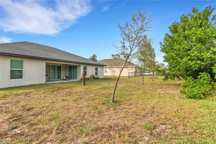 View of grassy yard with a patio area