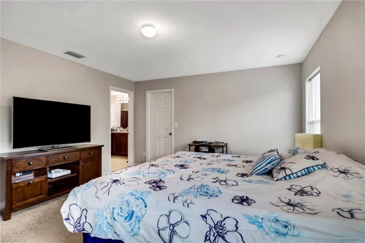 Bedroom with light colored carpet and ensuite bath