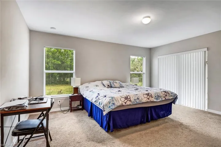 Carpeted bedroom featuring multiple windows