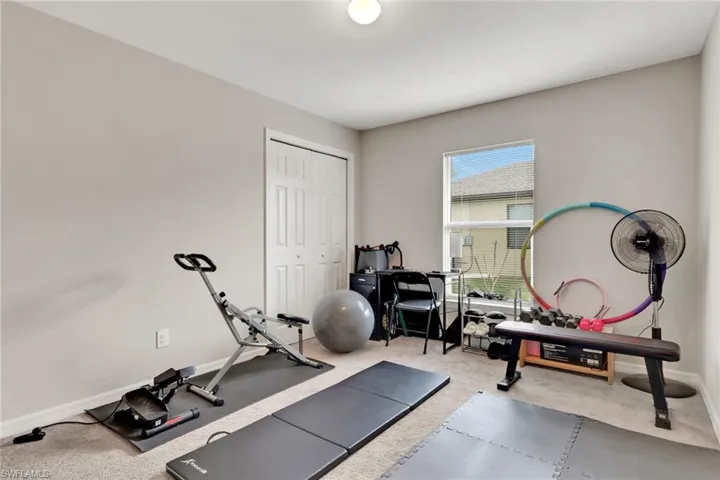 Workout room with baseboards and carpet flooring