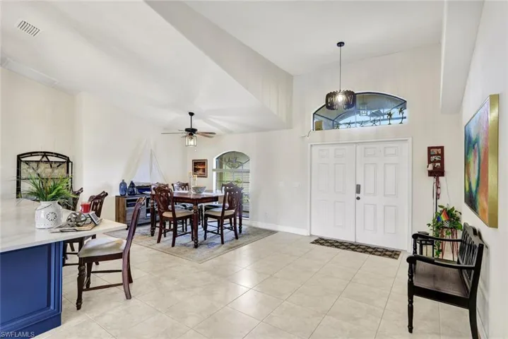 Entrance foyer featuring high vaulted ceiling, light tile patterned floors, and ceiling fan