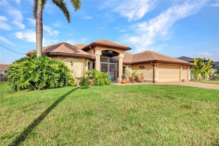 View of front of property featuring a garage, a front lawn, a tiled roof, stucco siding, and driveway