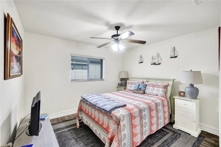 Bedroom with dark wood-style floors and ceiling fan