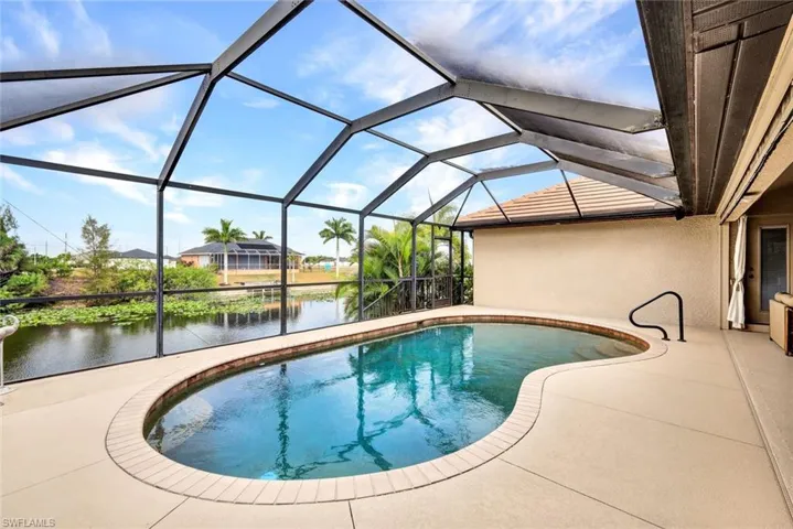 Swimming pool with a sunroom, a water view, a lanai, and a patio area