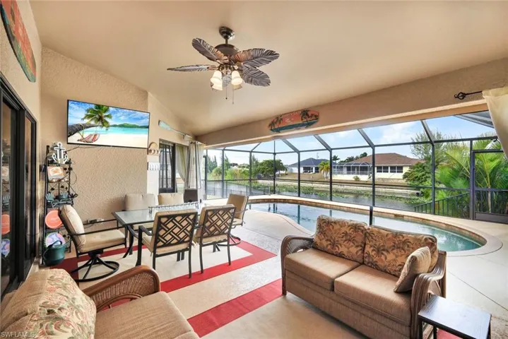 View of patio / terrace featuring an outdoor hangout area, a sunroom, ceiling fan, an outdoor pool, and a lanai
