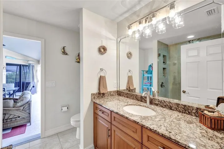 Bathroom featuring vanity, light tile patterned floors, connected bathroom, and a shower stall