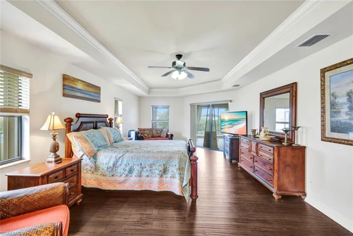 Bedroom with access to exterior, ornamental molding, dark wood-type flooring, ceiling fan, and multiple windows