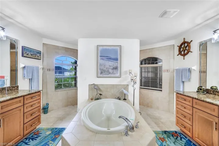 Bathroom with a garden tub, vanity, a walk in shower, and light tile patterned floors