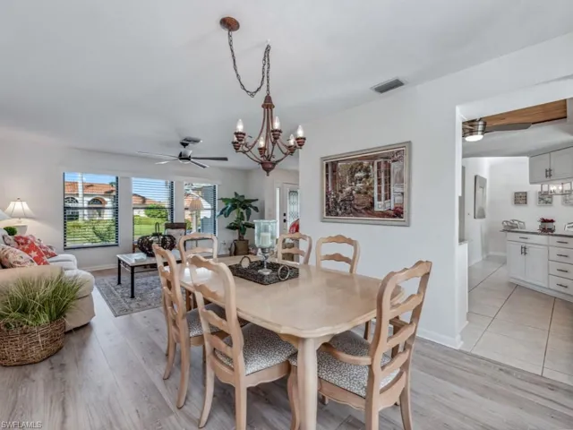 Dining area with ceiling fan with notable chandelier and light wood-type flooring