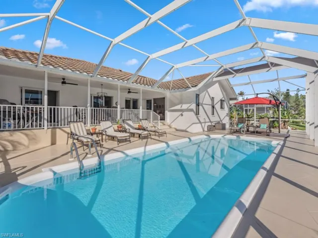 View of pool with ceiling fan, a lanai, and a patio