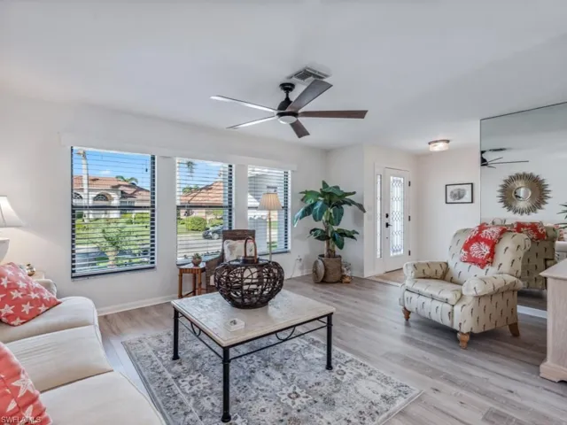 Living room featuring a wealth of natural light, ceiling fan, and light hardwood / wood-style floors