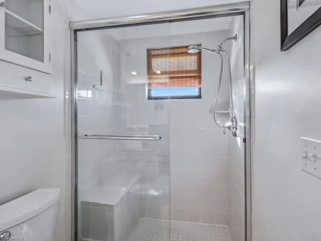 Bathroom featuring toilet and a shower with door