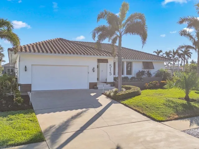 Mediterranean / spanish-style house featuring a front lawn and a garage