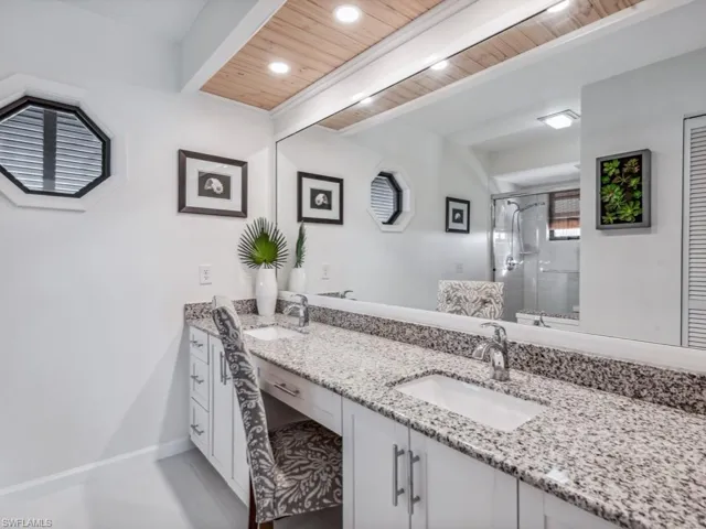 Bathroom with vanity, an enclosed shower, and wood ceiling