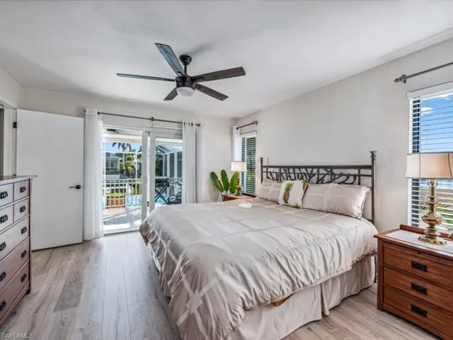 Bedroom featuring ceiling fan, light hardwood / wood-style flooring, access to outside, and multiple windows