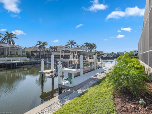 View of dock featuring glass enclosure and a water view