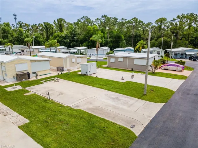 View of community with a residential view, view of scattered trees, a yard, and concrete driveway