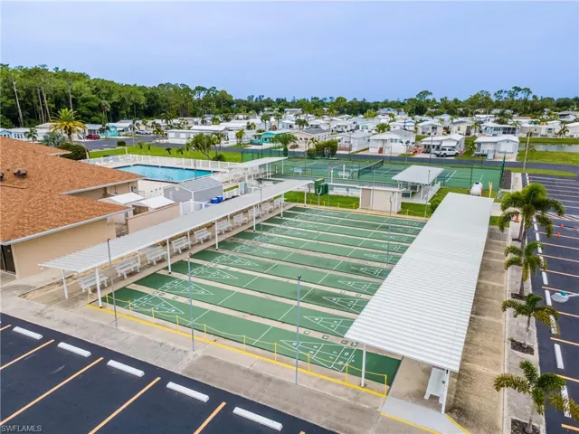 View of community with uncovered parking and shuffleboard