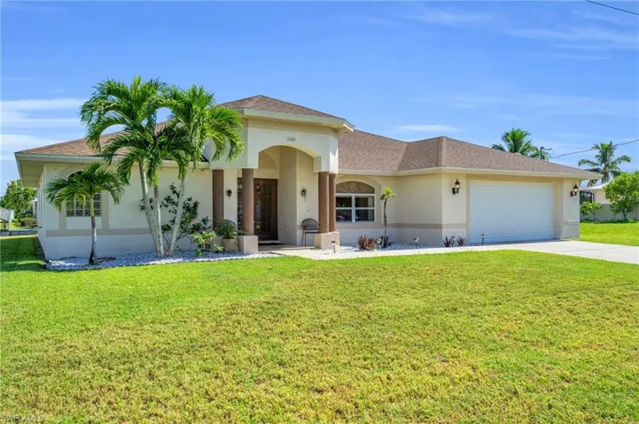 View of front of property with a garage and a front yard