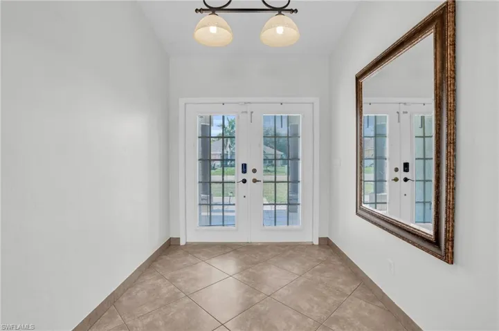Doorway with french doors and light tile patterned floors
