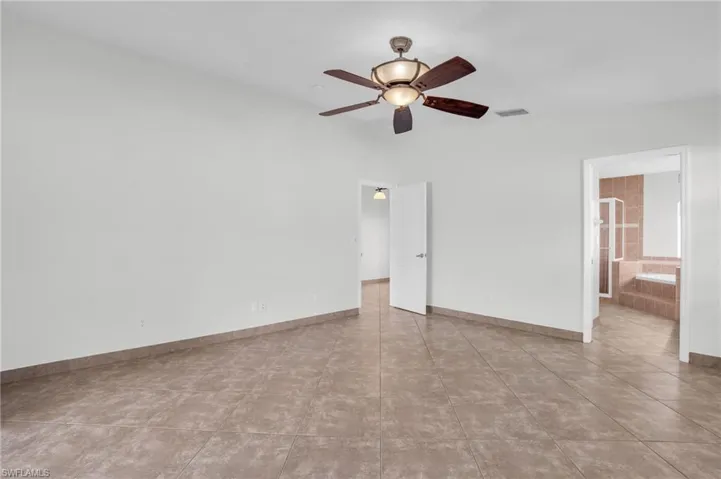 Tiled spare room with ceiling fan