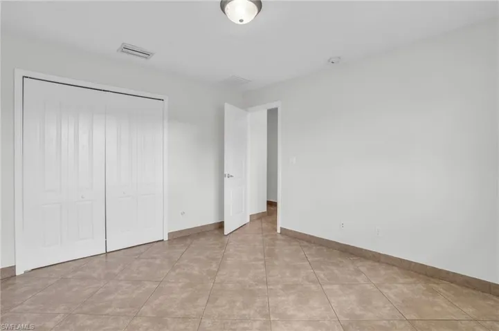 Unfurnished bedroom with a closet and light tile patterned floors