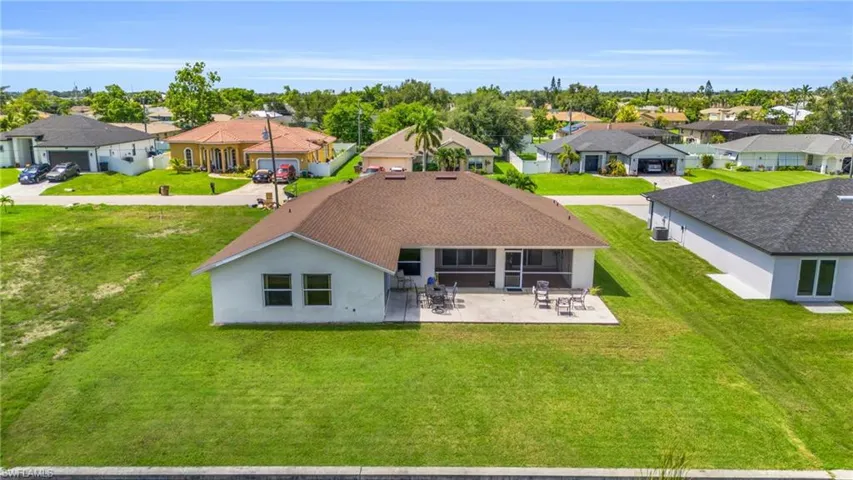 Rear view of property with a patio and a lawn