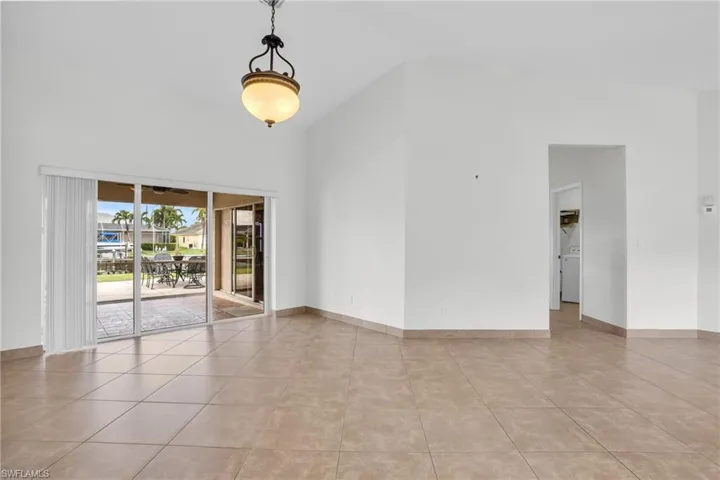 Tiled spare room featuring a towering ceiling