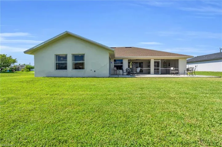 Rear view of house with a patio area and a lawn
