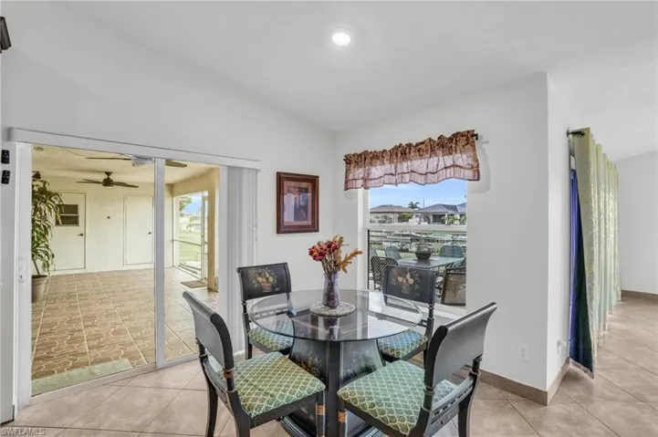 Tiled dining space featuring vaulted ceiling and ceiling fan