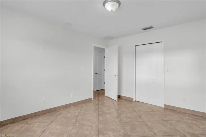 Unfurnished bedroom with a closet and light tile patterned floors