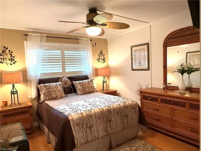 Bedroom featuring crown molding, ceiling fan, and wood finished floors