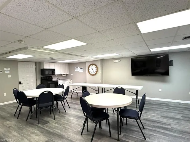 Dining room featuring dark wood-style floors and a drop ceiling
