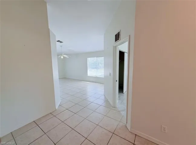 Hallway with light tile patterned floors and baseboards