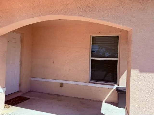 Doorway to property featuring stucco siding