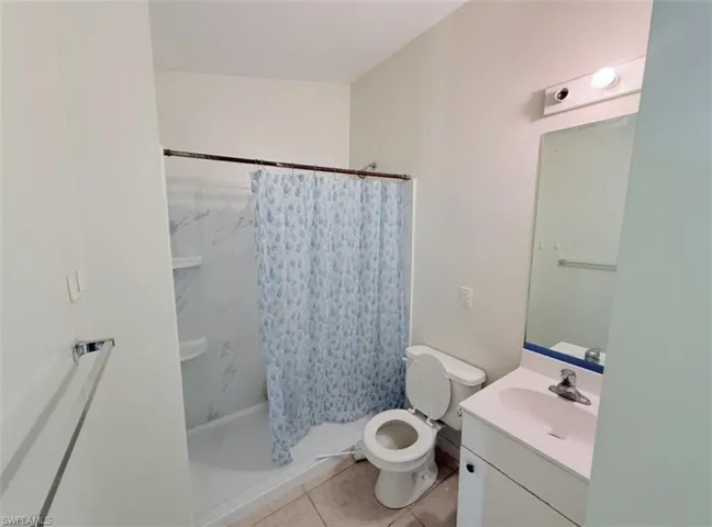 Bathroom featuring vanity, a stall shower, and light tile patterned flooring