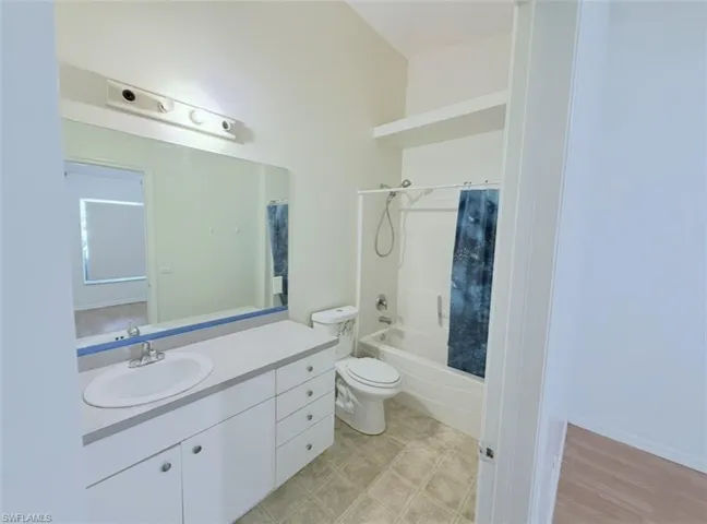 Bathroom with vanity and shower / bath combo with shower curtain