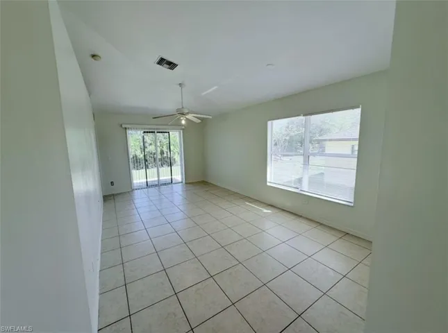 Unfurnished room featuring light tile patterned floors and ceiling fan