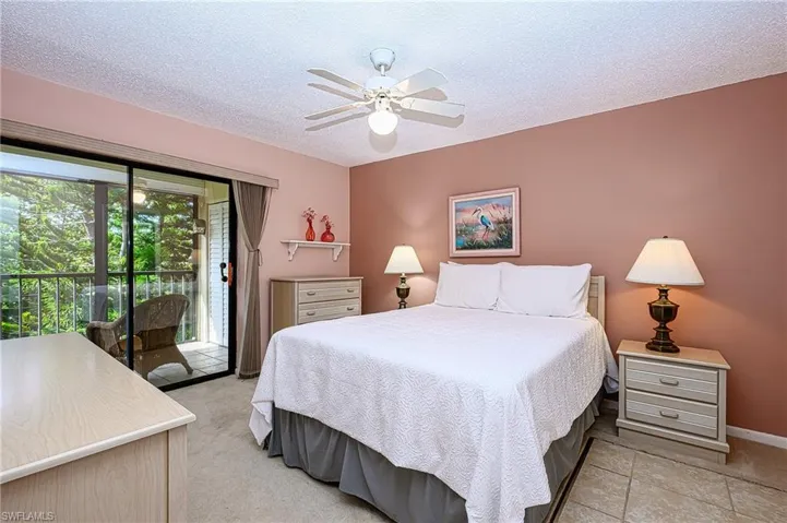 Bedroom featuring ceiling fan, access to exterior, and a textured ceiling