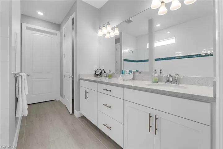 Dual vanity with white cabinetry and chrome hardware. 16160 Bluestem Ln. Babcock Ranch, FL 33982