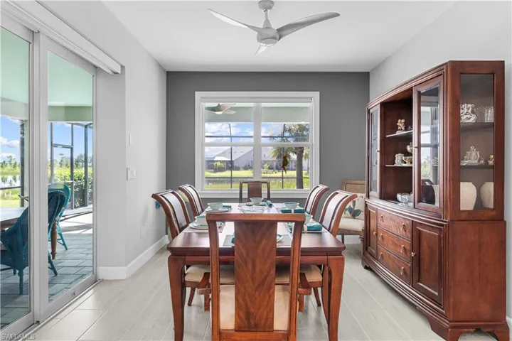 Dining area featuring a modern ceiling fan, custom tile flooring, and a large window. 16160 Bluestem Ln. Babcock Ranch, FL 33982