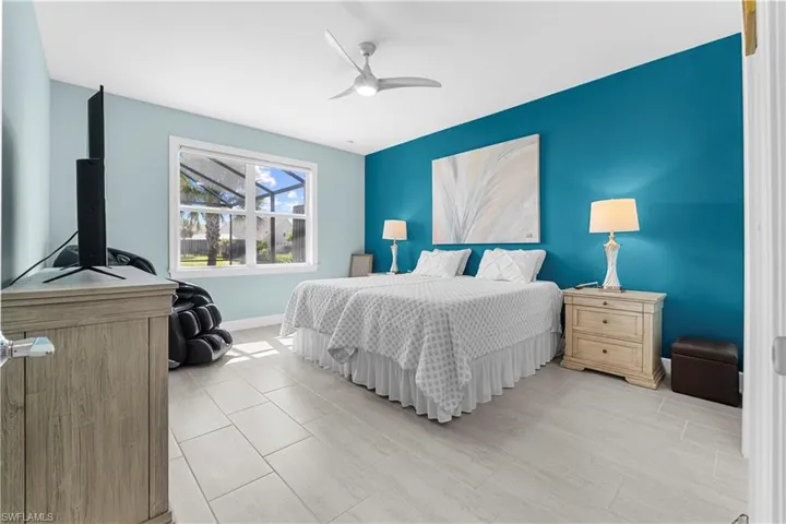 Light-toned plank flooring, prominent window, ceiling fan, and painted accent wall. 16160 Bluestem Ln. Babcock Ranch, FL 33982