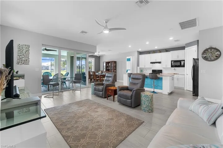 Open-concept living space featuring wood-finish flooring, shaker style white cabinetry, recessed lighting, and a ceiling fan. 16160 Bluestem Ln. Babcock Ranch, FL 33982