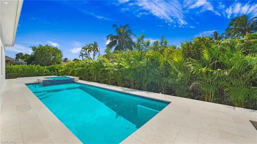 View of pool with a patio area and a pool with connected hot tub