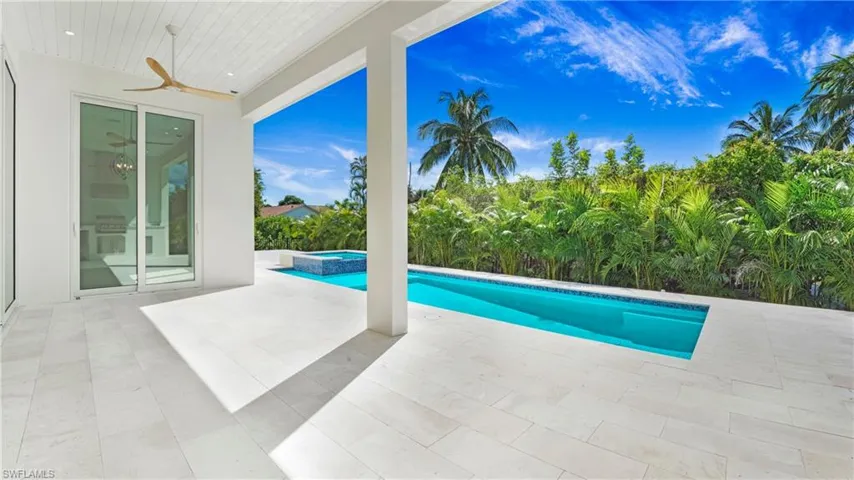 View of pool with ceiling fan, a patio area, and a pool with connected hot tub