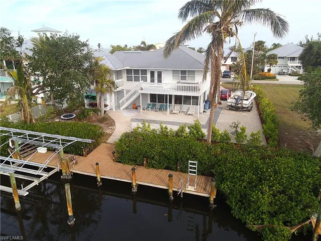 Rear view of house with a water view, a patio, and stairs