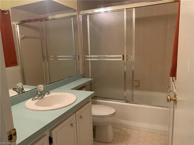 Full bathroom with vanity, tile patterned flooring, and shower / bath combination with glass door