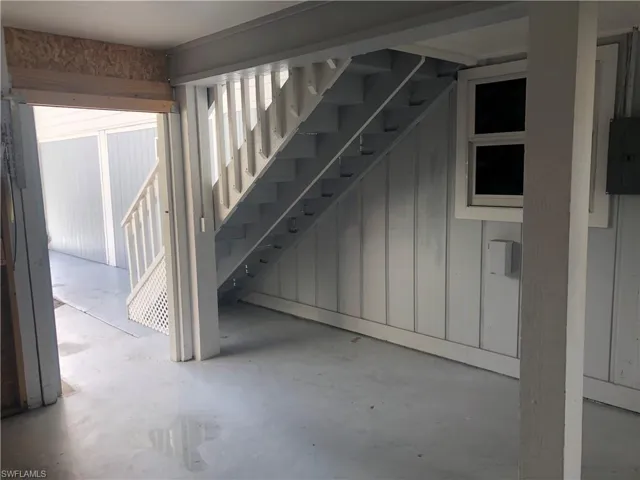 Basement featuring electric panel and stairs