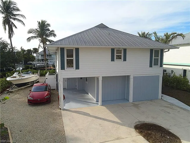 View of front facade with a metal roof, concrete driveway, and a garage